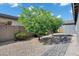 Backyard features desert landscaping, block wall, and a paved walkway leading through the serene outdoor space at 35733 W Santa Monica Ave, Maricopa, AZ 85138