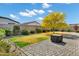 Spacious backyard featuring brick pavers, desert landscaping, grassy area and mature trees for added privacy at 35733 W Santa Monica Ave, Maricopa, AZ 85138