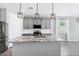 Modern kitchen with a large island, granite countertops, stainless steel appliances, and stylish pendant lighting at 35733 W Santa Monica Ave, Maricopa, AZ 85138