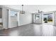 Open-concept living room with a large window, ceiling fan, and sliding glass doors that offer lots of natural light at 35733 W Santa Monica Ave, Maricopa, AZ 85138