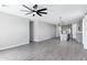 Open-concept living room with a modern kitchen and gray wood-look floors at 35733 W Santa Monica Ave, Maricopa, AZ 85138