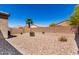 View of the backyard featuring gravel, block wall, a palm tree, and desert landscaping at 4992 E Rhodium Dr, San Tan Valley, AZ 85143