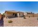 A spacious backyard featuring a patio, desert landscaping, and a block wall at 4992 E Rhodium Dr, San Tan Valley, AZ 85143