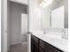 Bathroom featuring dual sinks, dark cabinets, and access to the bedroom at 4992 E Rhodium Dr, San Tan Valley, AZ 85143