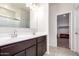 Bathroom featuring a double sink vanity, a large mirror, and access to the walk-in closet at 4992 E Rhodium Dr, San Tan Valley, AZ 85143