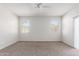 Spacious carpeted bedroom offers two windows and a ceiling fan at 4992 E Rhodium Dr, San Tan Valley, AZ 85143