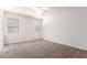 A clean, carpeted bedroom is brightened by two windows and a ceiling fan at 4992 E Rhodium Dr, San Tan Valley, AZ 85143
