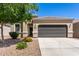 Charming single-story home with a well-maintained yard and a two-car garage on a sunny day at 4992 E Rhodium Dr, San Tan Valley, AZ 85143