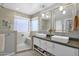 Bathroom featuring double sinks, large mirrors and a walk-in shower at 15391 W Yucatan Dr, Surprise, AZ 85379