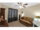 Bedroom with a ceiling fan, tan sofa, and neutral colored walls at 15391 W Yucatan Dr, Surprise, AZ 85379