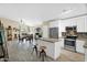 Modern kitchen with stainless steel appliances and center island seamlessly flows to the open dining room at 15391 W Yucatan Dr, Surprise, AZ 85379