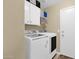 Convenient laundry area featuring white front-load machines, storage cabinets, and shelving for organized living at 15391 W Yucatan Dr, Surprise, AZ 85379