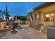 Outdoor kitchen and dining area under a covered patio, featuring a built-in grill and desert landscaping at 16183 W Monterey Way, Goodyear, AZ 85395