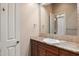 Bathroom with vanity and granite countertop, framed mirror, decorative sconces, and neutral tile surround at 22635 N 54Th Pl, Phoenix, AZ 85054