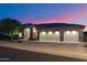 Elegant home exterior featuring a three-car garage and a beautifully landscaped front yard at dusk at 22635 N 54Th Pl, Phoenix, AZ 85054