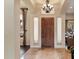 Grand foyer with a wooden front door, archways and decorative chandelier, creating an elegant entrance at 22635 N 54Th Pl, Phoenix, AZ 85054