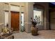 Inviting front entrance with a charming, covered patio featuring a wooden door and stylish outdoor seating at 22635 N 54Th Pl, Phoenix, AZ 85054