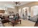 Spacious living room featuring a leather sofa, ceiling fan, and access to other rooms through elegant archways at 22635 N 54Th Pl, Phoenix, AZ 85054