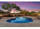 Inviting backyard pool featuring a stone fireplace and seating area under a colorful sunset sky at 22635 N 54Th Pl, Phoenix, AZ 85054