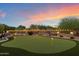 Backyard putting green enclosed by a decorative fence with ambient lighting and lush landscaping at 22635 N 54Th Pl, Phoenix, AZ 85054