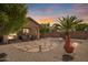 Expansive backyard with custom stone accents and a cozy covered patio ideal for entertaining guests at 30374 N Sunray Dr, Queen Creek, AZ 85143