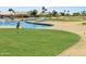 Scenic golf course view featuring a water hazard with fountains and palm trees, enhancing the landscape at 30374 N Sunray Dr, Queen Creek, AZ 85143