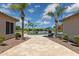 Backyard with a stone patio, pool, palm trees, blue umbrella and clear skies at 3356 E Vallejo Ct, Gilbert, AZ 85298