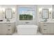 Luxurious bathroom showcasing a soaking tub with a view between dual vanities at 3356 E Vallejo Ct, Gilbert, AZ 85298