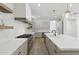 Well-lit modern kitchen with stainless appliances, floating shelves, gas range, and stone counter tops at 3356 E Vallejo Ct, Gilbert, AZ 85298