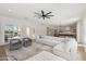 Bright living room featuring a large white sectional sofa, armchairs, and access to outdoor pool area at 3356 E Vallejo Ct, Gilbert, AZ 85298