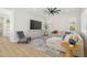 Bright living room with wood-look floors, neutral furnishings, and a modern ceiling fan at 3356 E Vallejo Ct, Gilbert, AZ 85298