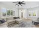 Open living room featuring wood-look floors, large windows, and neutral-toned sectional sofa at 3356 E Vallejo Ct, Gilbert, AZ 85298
