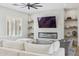 Living room featuring a modern fireplace with a large television and floating shelves at 3356 E Vallejo Ct, Gilbert, AZ 85298