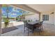 Covered patio with outdoor dining, view of pool, palm trees and blue skies at 3356 E Vallejo Ct, Gilbert, AZ 85298
