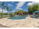 Backyard pool with water features, outdoor kitchen, patio furniture, palm trees, flowers and clear blue skies at 3356 E Vallejo Ct, Gilbert, AZ 85298