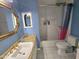A stylish bathroom featuring blue walls, granite countertops, and a tub with shower at 3722 E Glade Ave, Mesa, AZ 85206