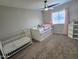 Bright bedroom with a toddler's bed, plush carpet, and window with pale pink curtains at 3722 E Glade Ave, Mesa, AZ 85206