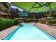 Community pool with lounge chairs and umbrellas and mature landscaping at 7131 E Rancho Vista Dr # 1008, Scottsdale, AZ 85251