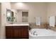 Well-lit bathroom boasts a soaking tub with tile surround, a spacious vanity, and a large mirror at 7445 E Eagle Crest Dr # 1015, Mesa, AZ 85207