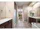 Bright bathroom featuring dual vanities, a walk-in shower, soaking tub, and access to the outdoor living space at 7445 E Eagle Crest Dr # 1015, Mesa, AZ 85207