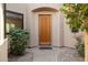 Inviting front entrance featuring a solid wood door, manicured shrubs, and a stone pathway leading to the entrance at 7445 E Eagle Crest Dr # 1015, Mesa, AZ 85207