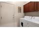 Functional laundry room equipped with a washer, dryer, storage cabinets, and access to a door at 7445 E Eagle Crest Dr # 1015, Mesa, AZ 85207