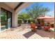 Outdoor patio featuring stone pavers, patio furniture, manicured shrubs and trees, and red patio umbrella at 7445 E Eagle Crest Dr # 1015, Mesa, AZ 85207