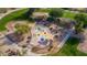 Aerial view of the community splash pad and playground with shaded seating areas in a green park setting at 7445 E Eagle Crest Dr # 1015, Mesa, AZ 85207