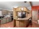 Open kitchen with breakfast bar, wood cabinetry, and modern appliances for easy meal prep at 11596 W Sierra Dawn Blvd # 307, Surprise, AZ 85378