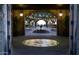 View through arched doorway to a stone-paved courtyard with a central fountain and trees decorated with string lights at 12940 W Creosote Dr, Peoria, AZ 85383
