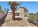 A spacious backyard with a covered patio, gravel ground cover, and a mature palm tree at 13676 N 73Rd Dr, Peoria, AZ 85381