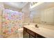 Bathroom with colorful shower curtain, single sink vanity and toilet at 13676 N 73Rd Dr, Peoria, AZ 85381