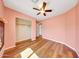 Bright bedroom featuring wood flooring, a ceiling fan, and a closet for ample storage at 13676 N 73Rd Dr, Peoria, AZ 85381