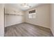 Bright bedroom featuring neutral walls, gray wood floors, and a window for natural light at 13676 N 73Rd Dr, Peoria, AZ 85381